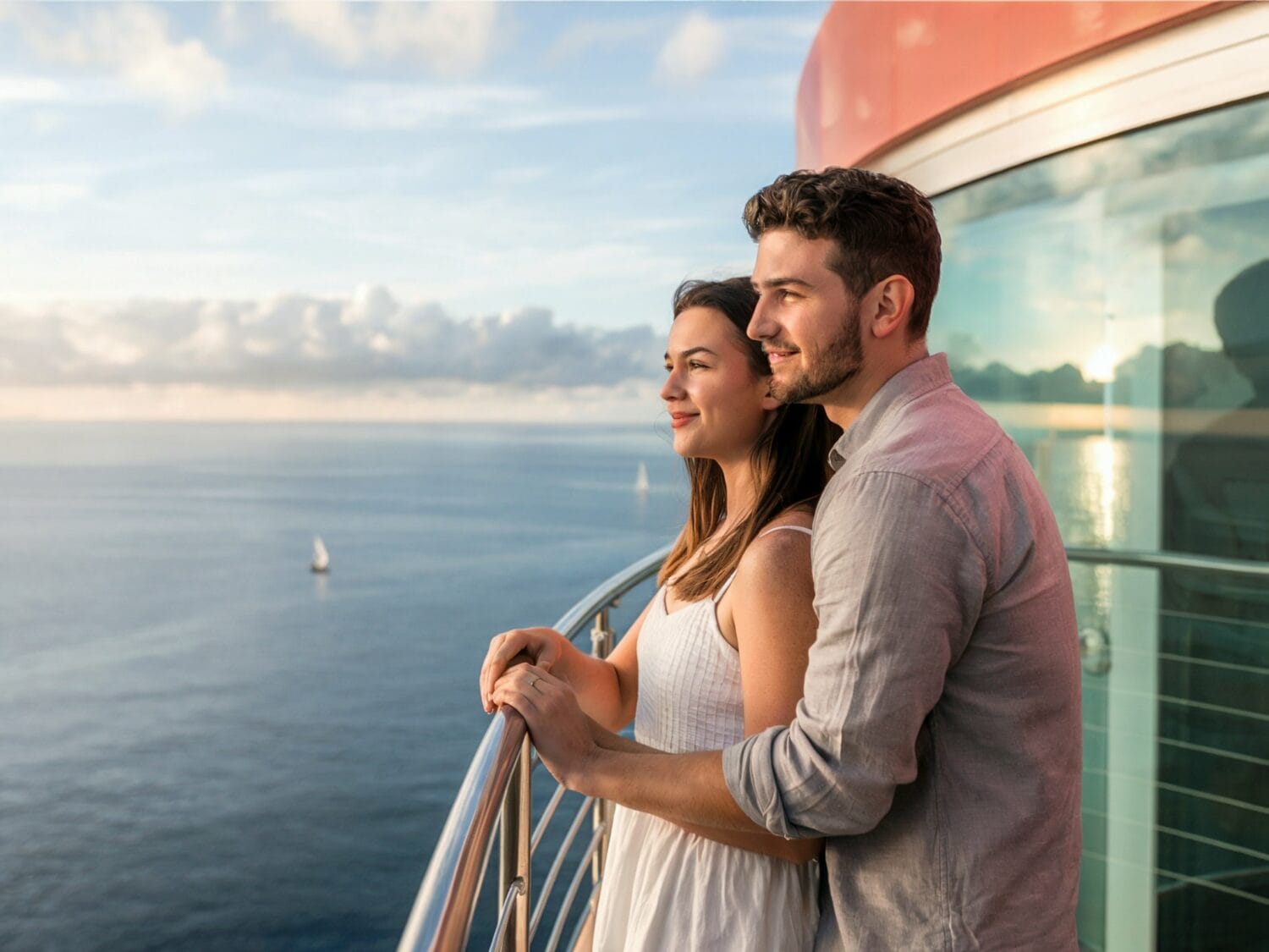 A millennial couple on balcony of luxury cruise ship