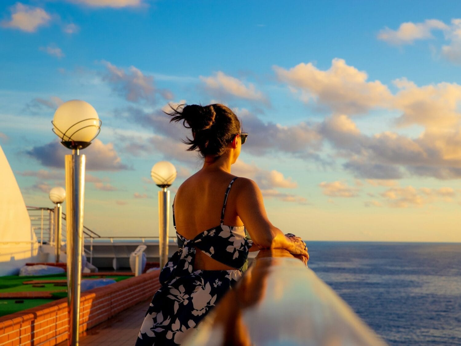 Woman on cruise deck looking at ocean - Image by Vinicius on Unsplash