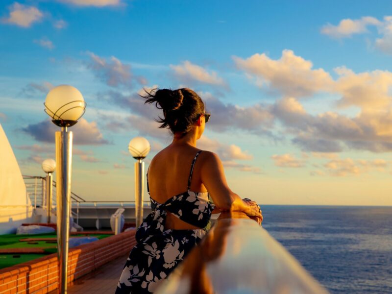 Woman on cruise deck looking at ocean - Image by Vinicius on Unsplash