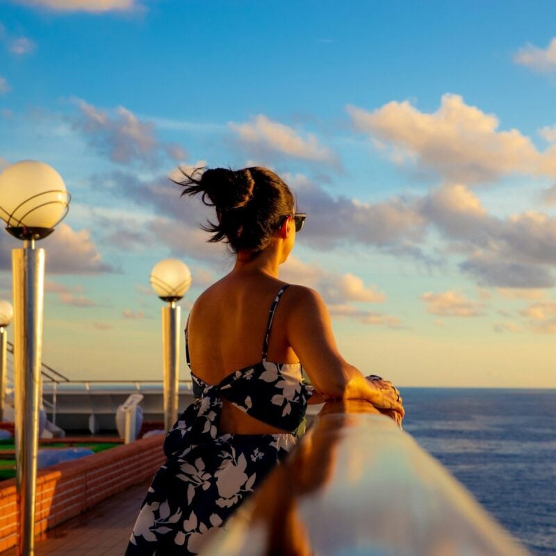 Woman on cruise deck looking at ocean - Image by Vinicius on Unsplash