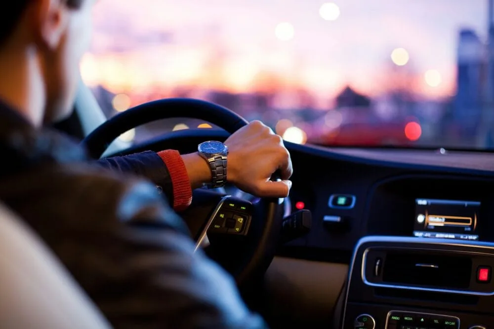 Hand on Steering Wheel - Image by Why Kei on Unsplash